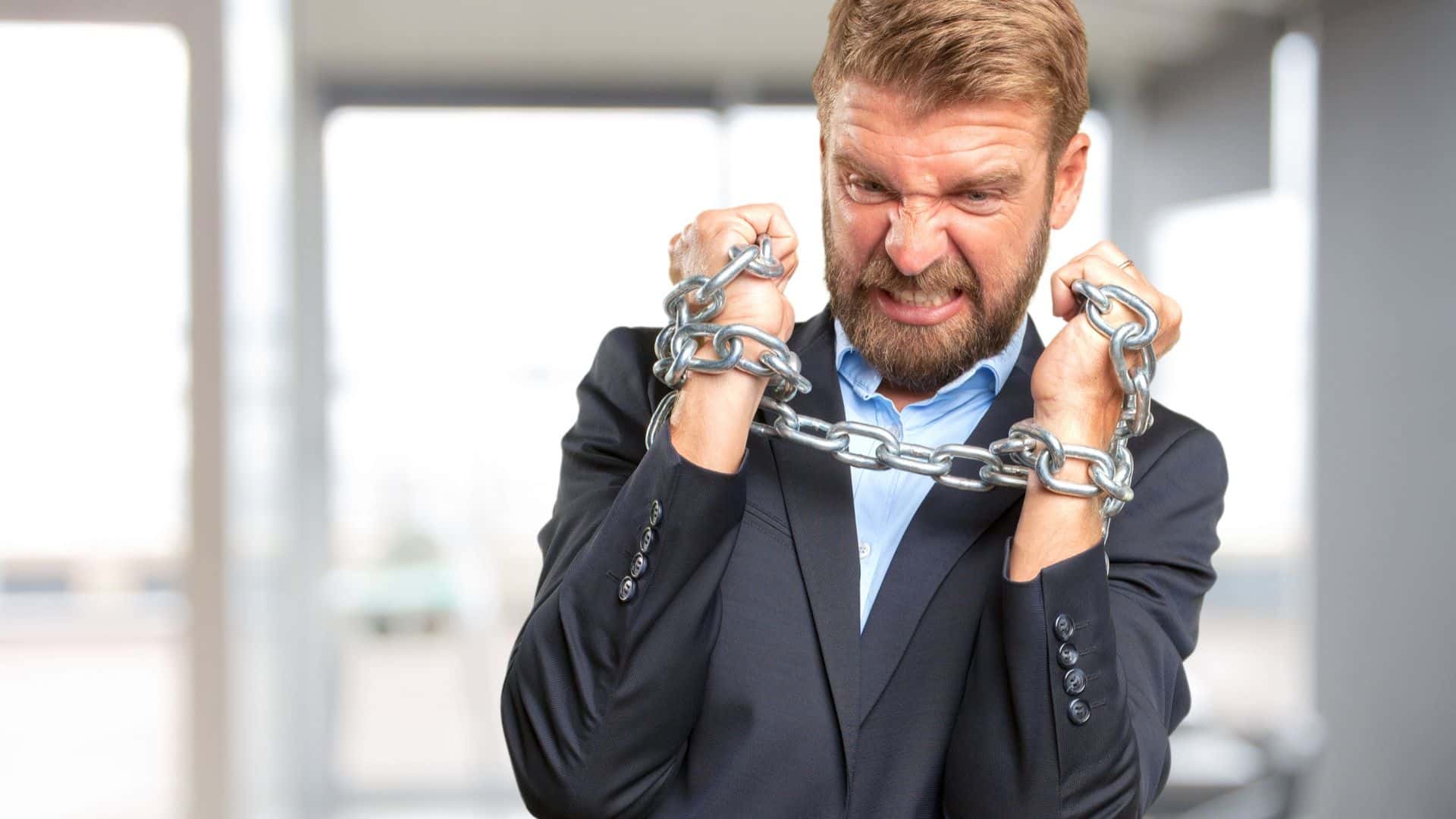 Homem nervoso e preso com correntes