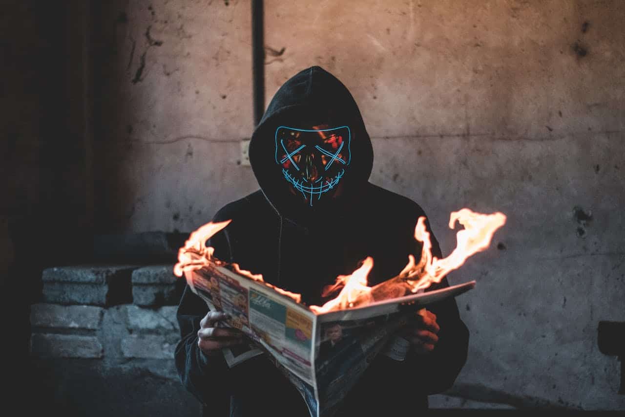 Bitcoin: Mensagens Sinistras Precedem Movimento Nervoso de Bilhões! 1 Hacker com jornal pegando fogo em maos