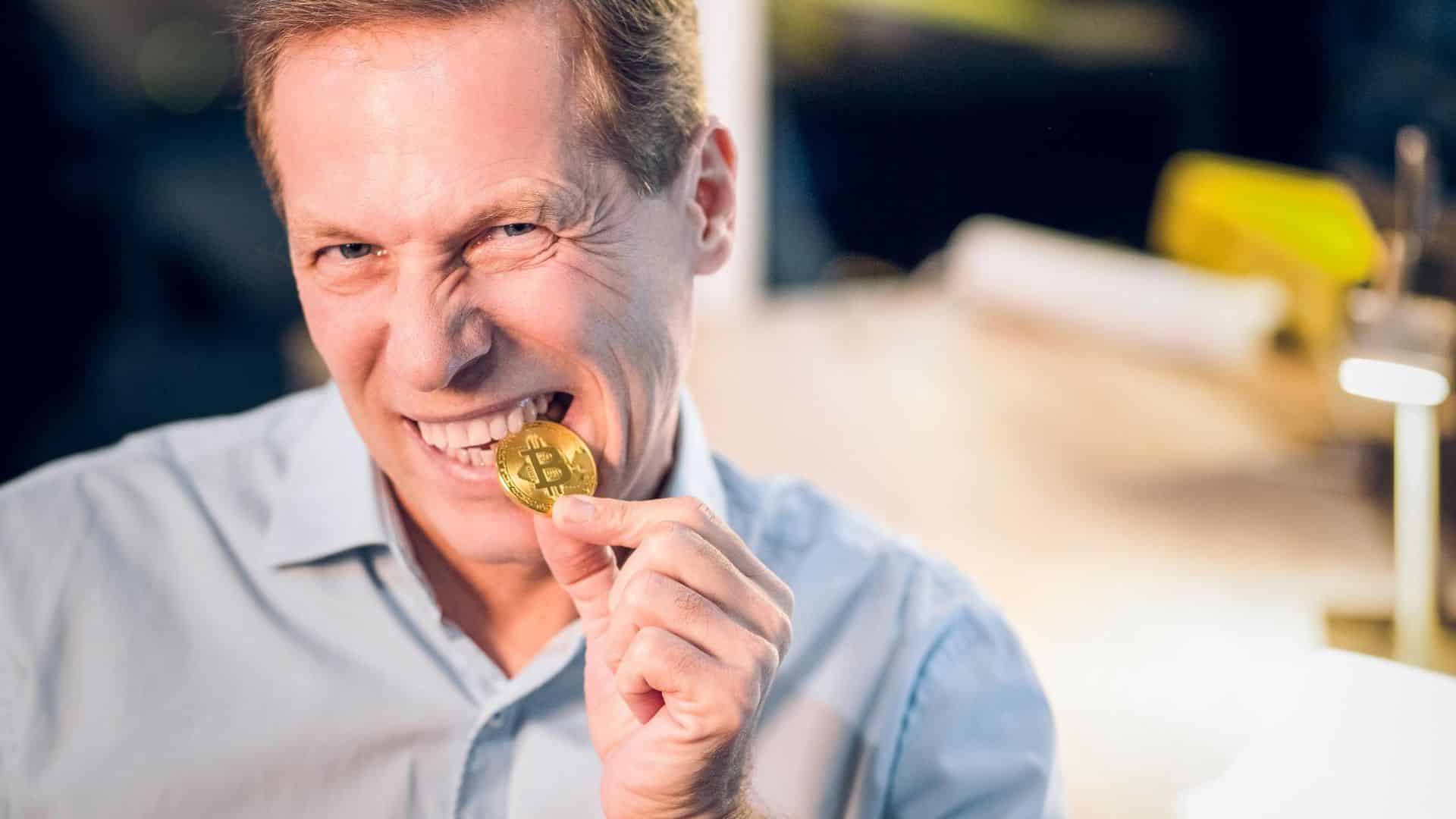 Homem mordendo bitcoin