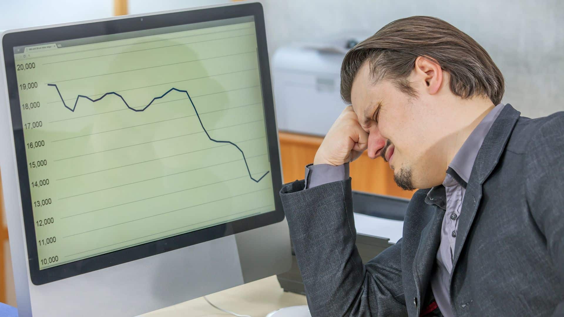 Investidor chateado ao observar grafico em queda