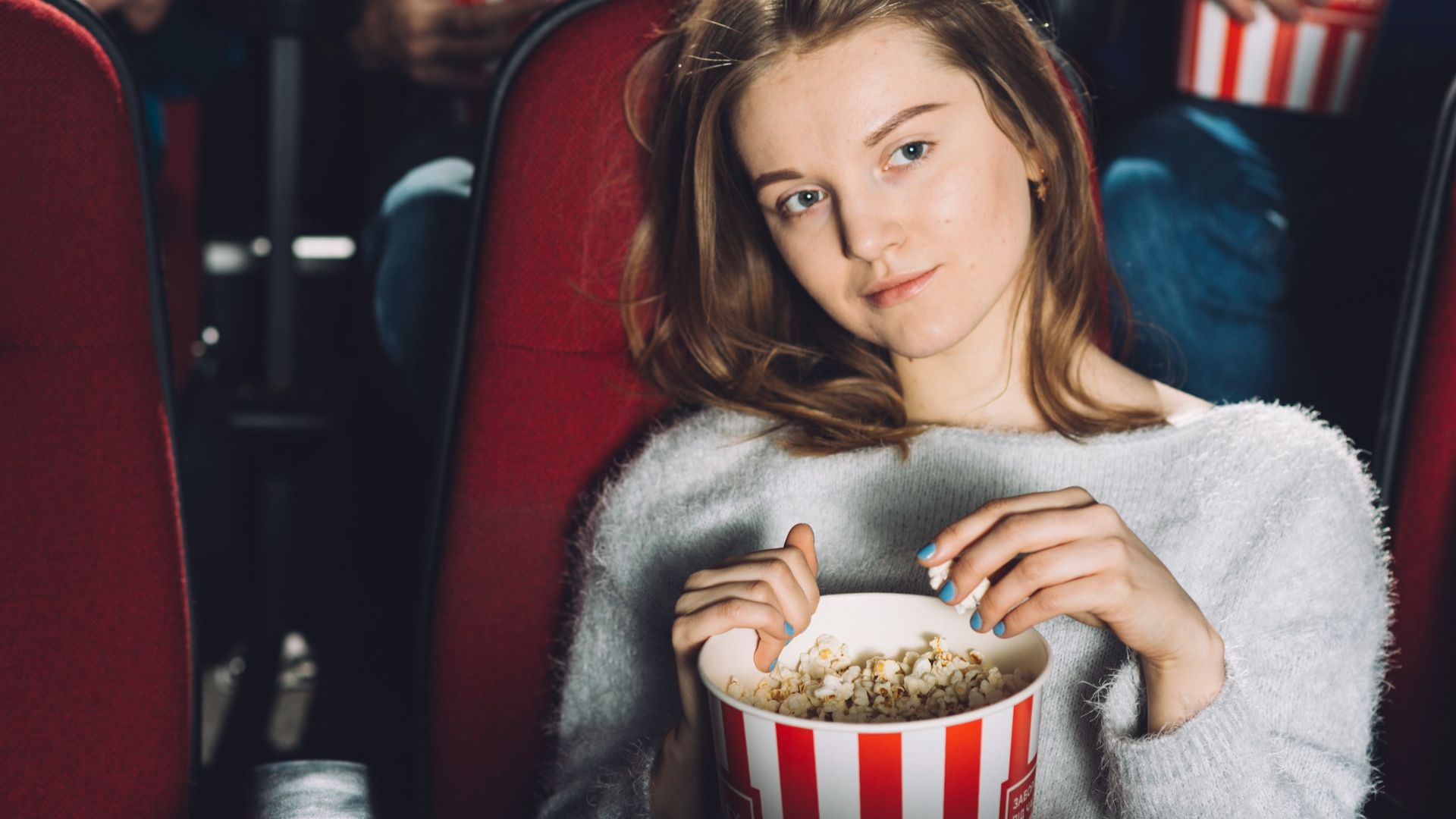 Heróis do Bitcoin: Ação Explosiva e Tesouros na Netflix! 1 Jovem assistindo filme com pipoca