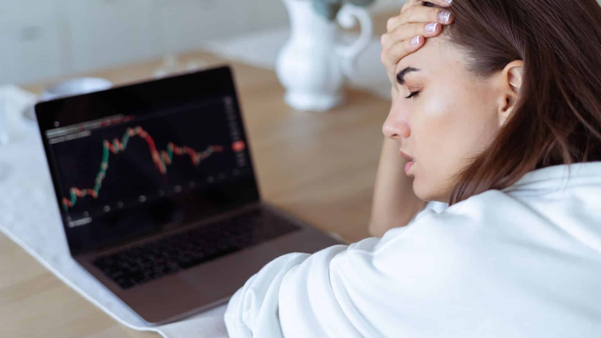 Jovem preocupada com queda nos graficos de investimentos