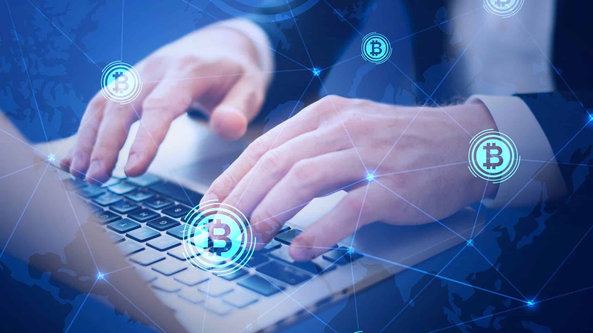 Mao de programador em teclado com bitcoins voando