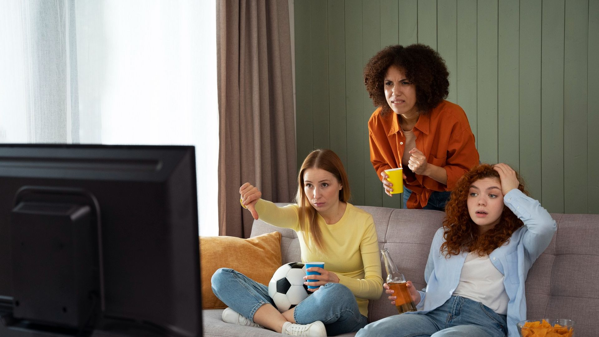 Mulheres tristes assistindo jogo de futebol