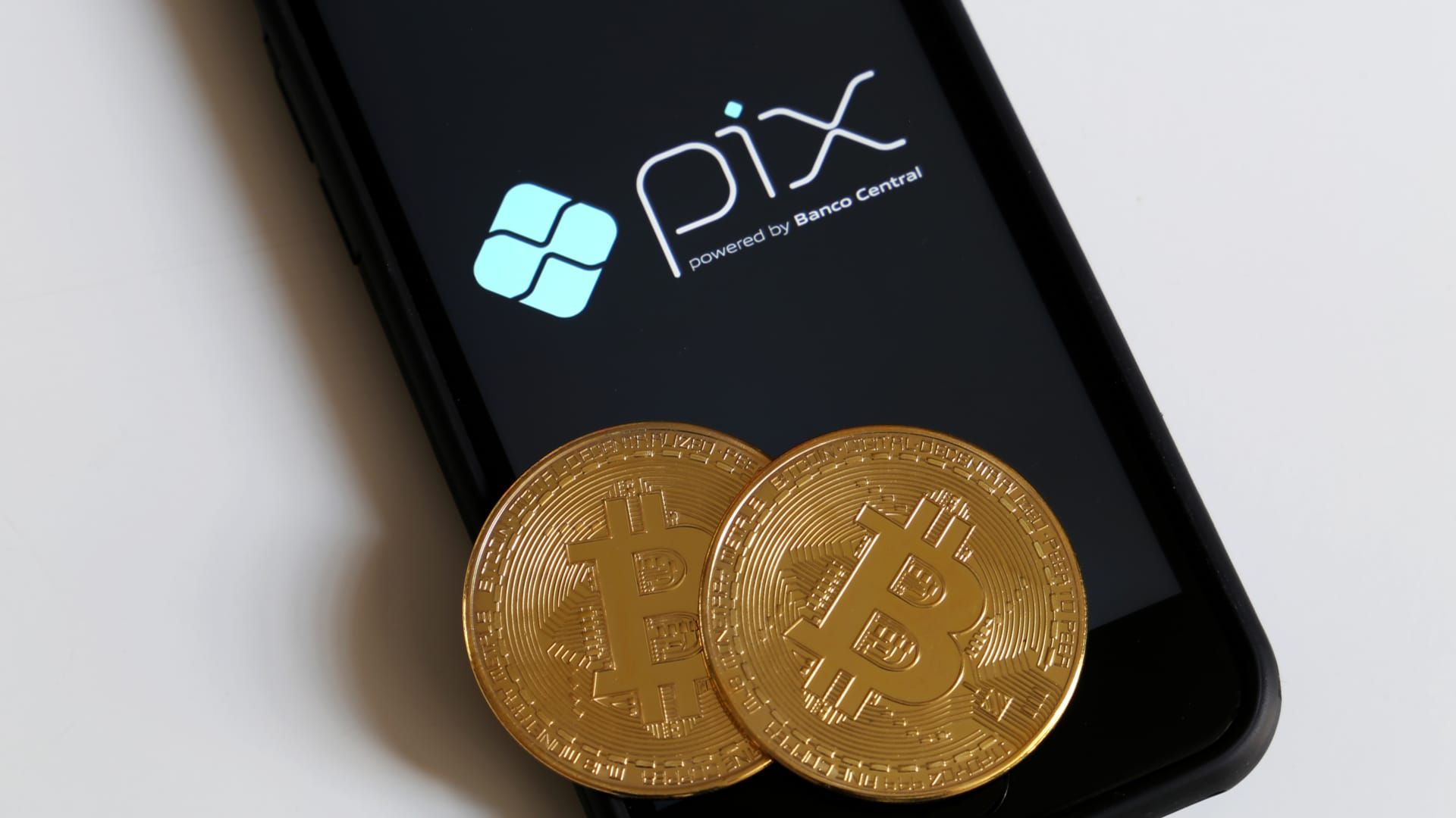 Vendedores de Bitcoin em Perigo: Ataques Hacker no Pix Alarmam! 1 Bitcoin sobre celular com tela do PIX