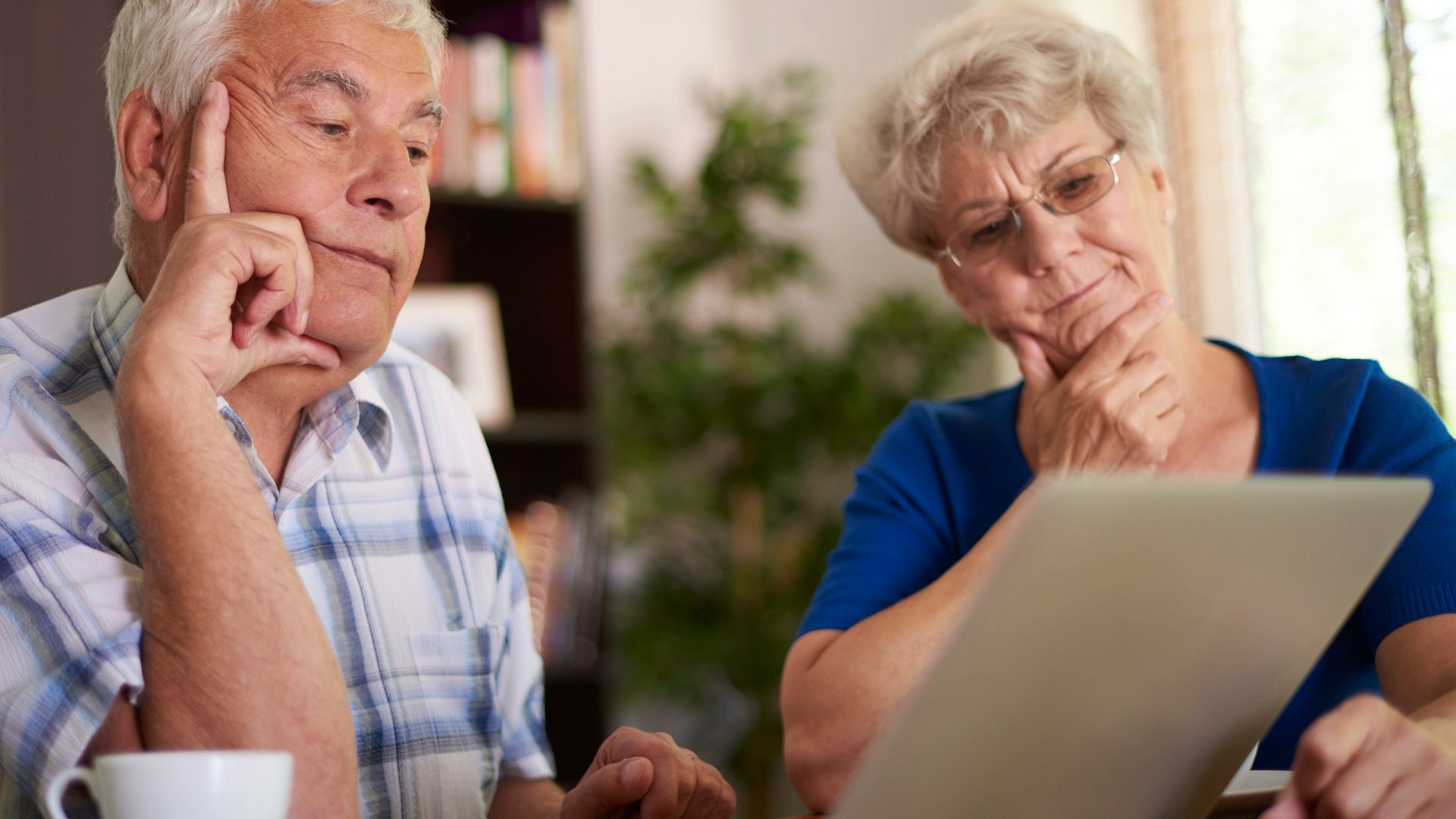Idosos analisando computador com desconfianca