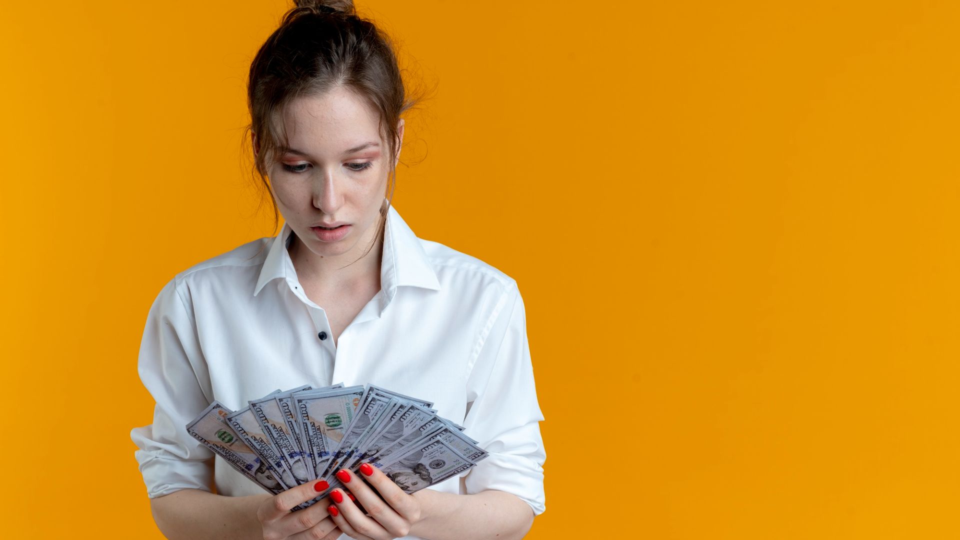Mulher olhando para notas de dinheiro