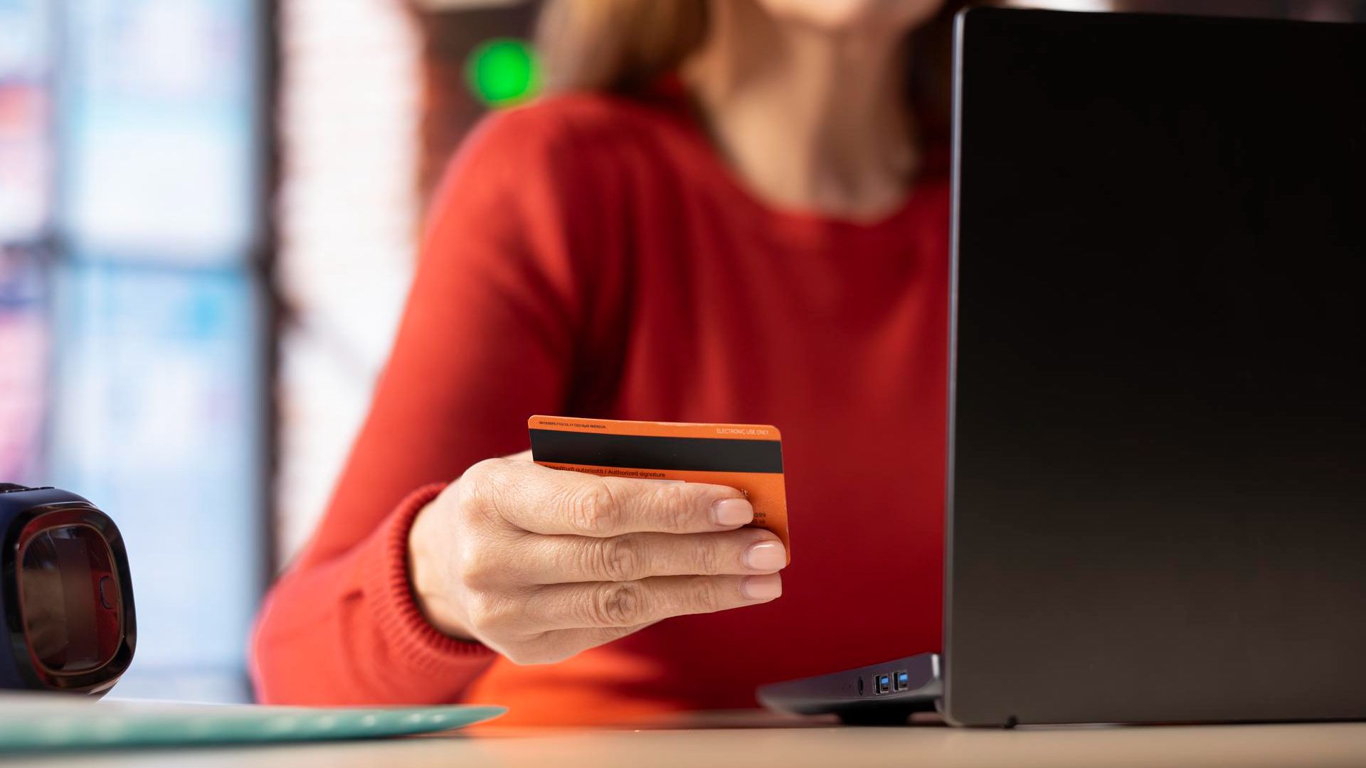 Itaú Lança Divisão Exclusiva para Criptoativos: Revolução à Vista! 1 Mulher segurando cartao laranja