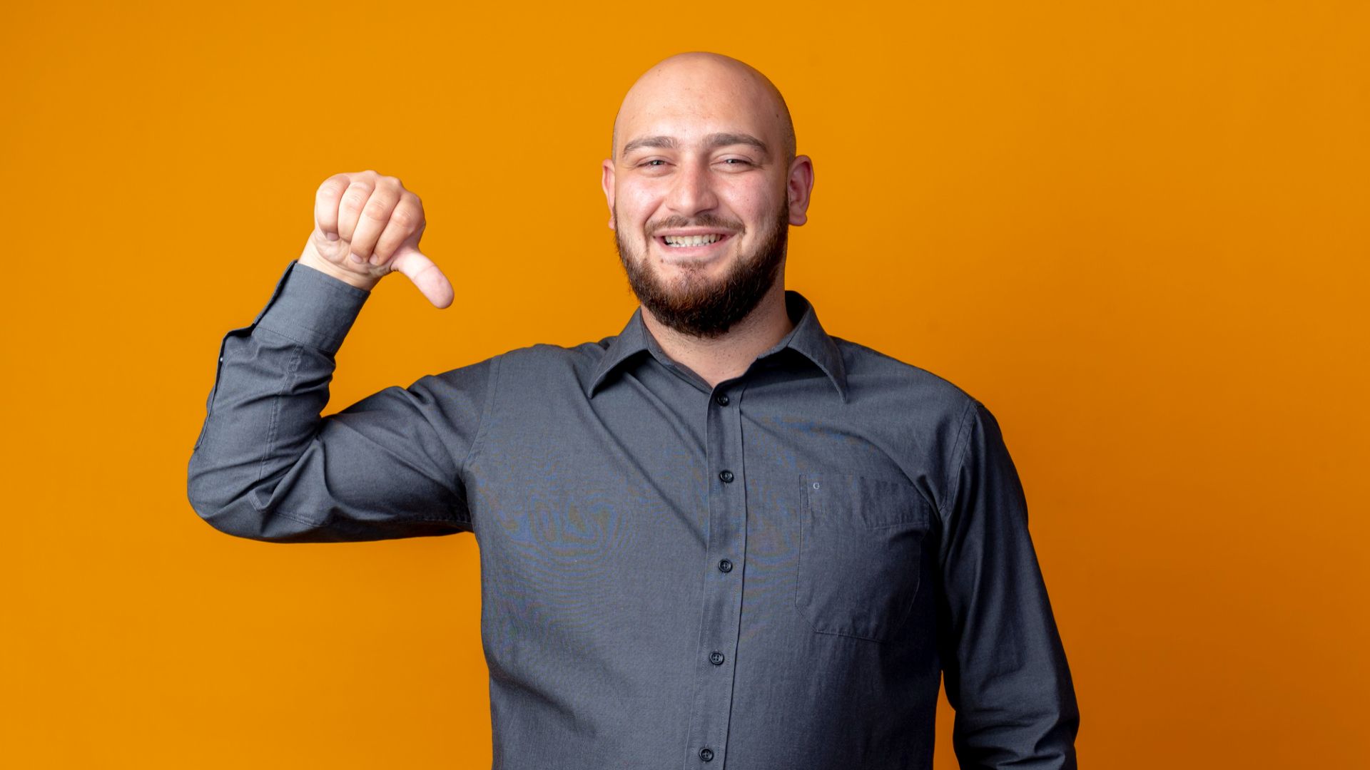 Homem apontando para baixo com dedo e fundo laranja