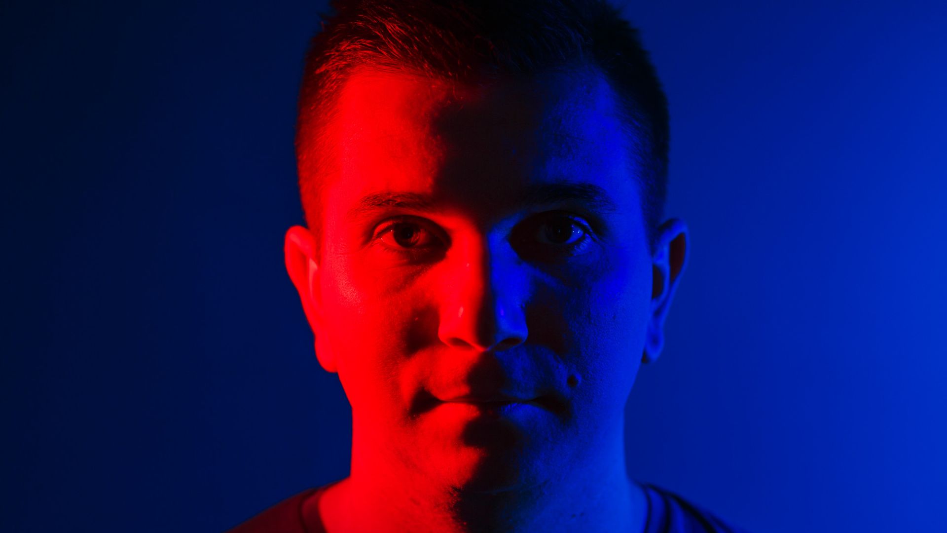 Homem com iluminacao dupla vermelha e azul