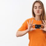 Revolução na Pagamento: Foxbit Pay Une Forças com Shipay nas Maquininhas! 4 Mulher com camisa laranja segurando cartao