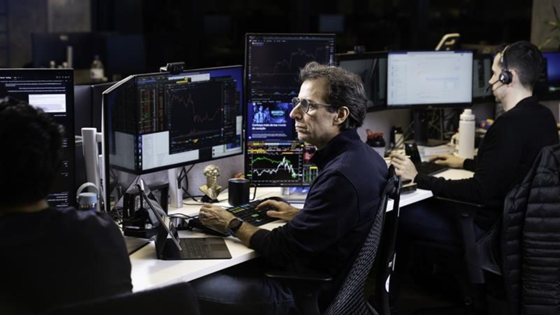 Andre Portilho com telas de negociacao em aberto executivo do BTG Pactual e Mynt