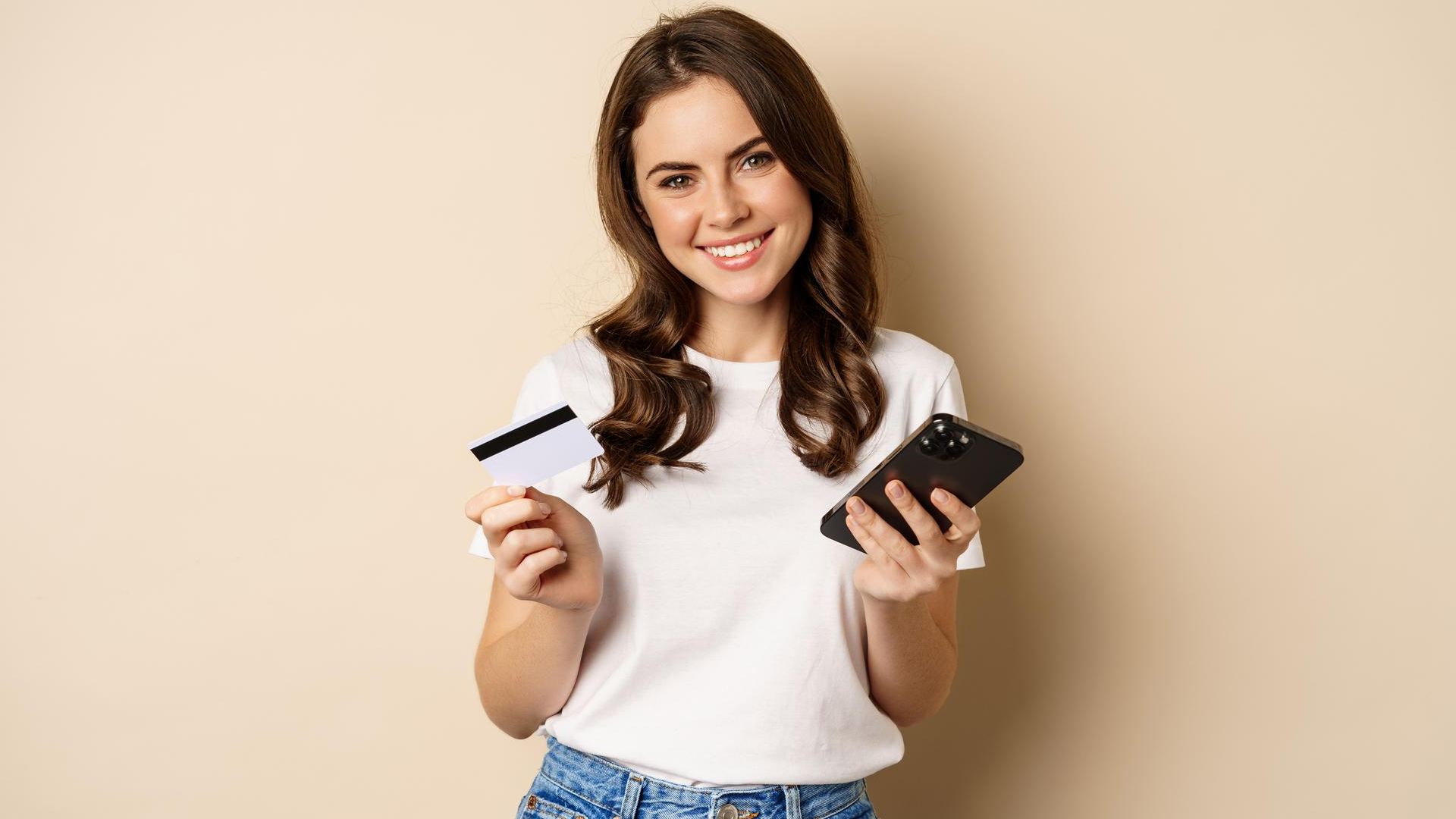 Ripple revoluciona o mercado: liquidação em stablecoin com gigantes Mastercard, WebBank e Gemini! 2 Mulher segurando cartao e celular sorrindo