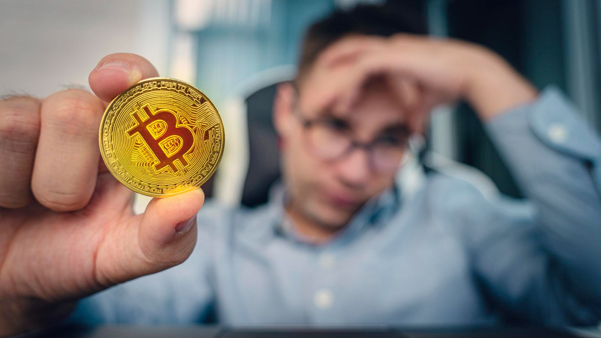 Homem preocupado ao fundo segurando bitcoin