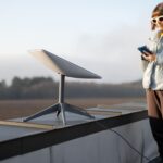 Mulher proxima de antena da Starlink