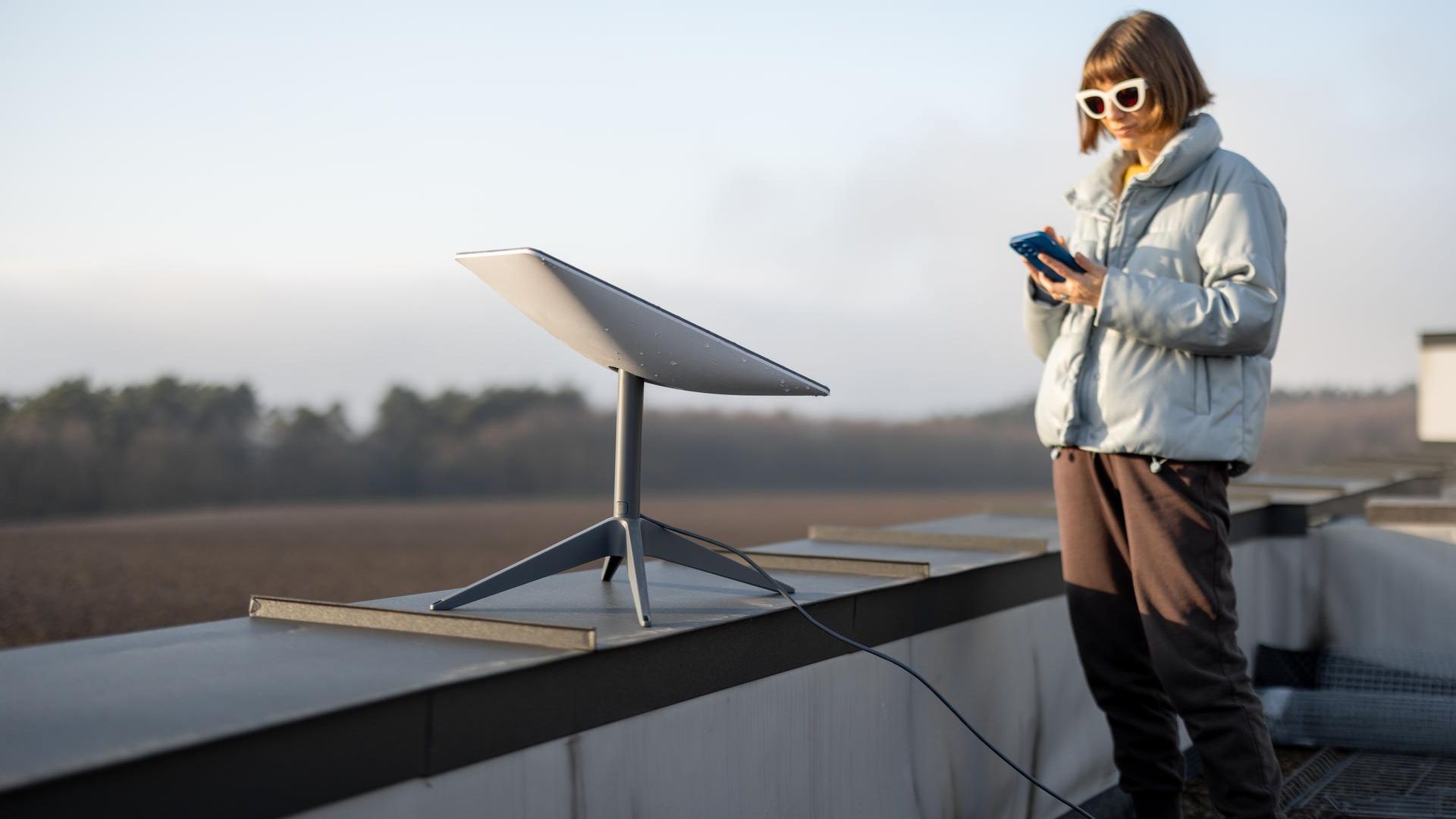 Mulher proxima de antena da Starlink