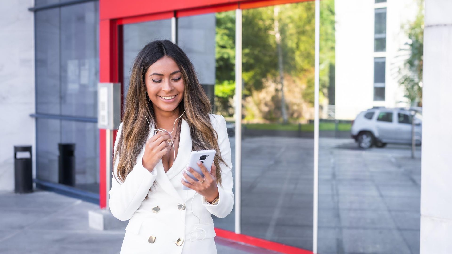 Santander Brasil Abrindo Caminhos: A Revolução das Criptomoedas Está Aqui! 2 Mulher sorrindo na porta de agencia bancaria com fachada vermelha