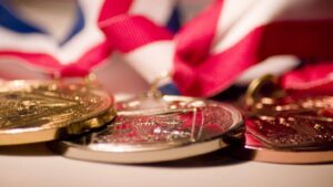 Enquanto o ouro brilha, Ibovespa desponta e Bitcoin fica para trás! Descubra os investimentos explosivos de 2025! 5 medalhas 1200x675 1