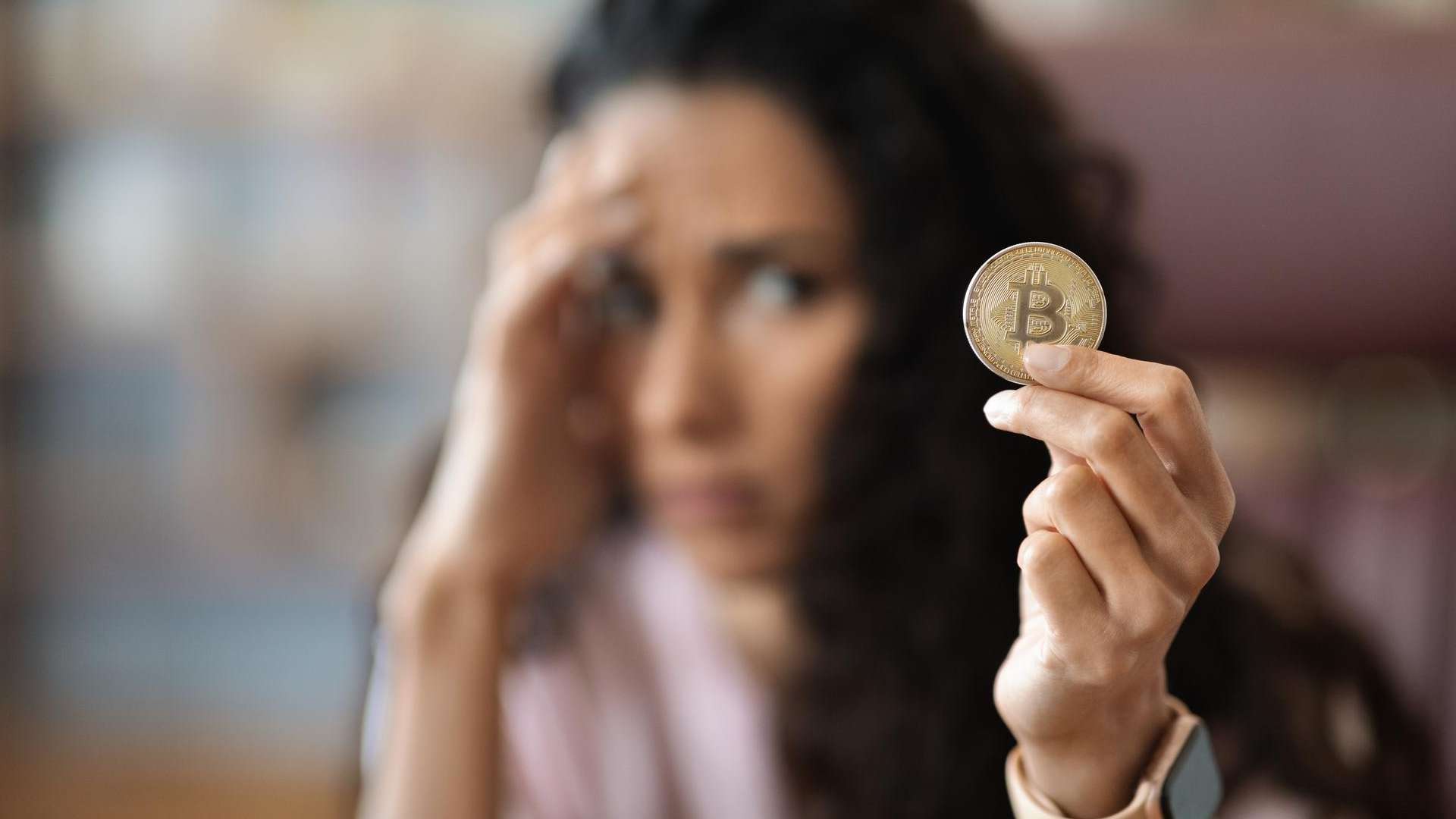 Mulher preocupada com bitcoin na mao