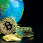 Globo terrestre mirando no Brasil com bitcoin proximo