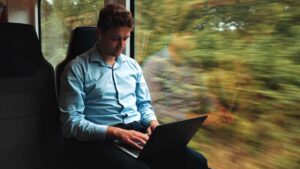 Empregos de Elite à Beira do Fim em 2030: O que Fazer para se Salvar? 5 investidor olhando seus investimentos em viagem de trem turismo