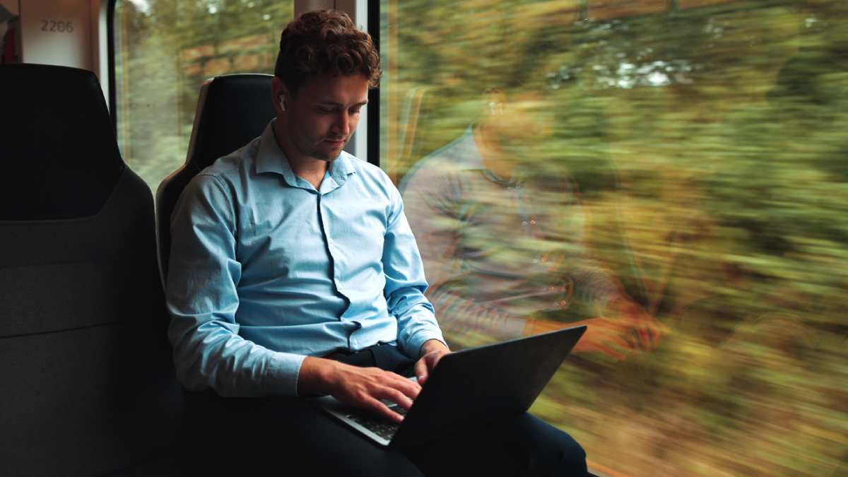 investidor olhando seus investimentos em viagem de trem turismo