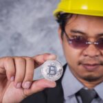 Minerador olhando para bitcoin com preocupacao