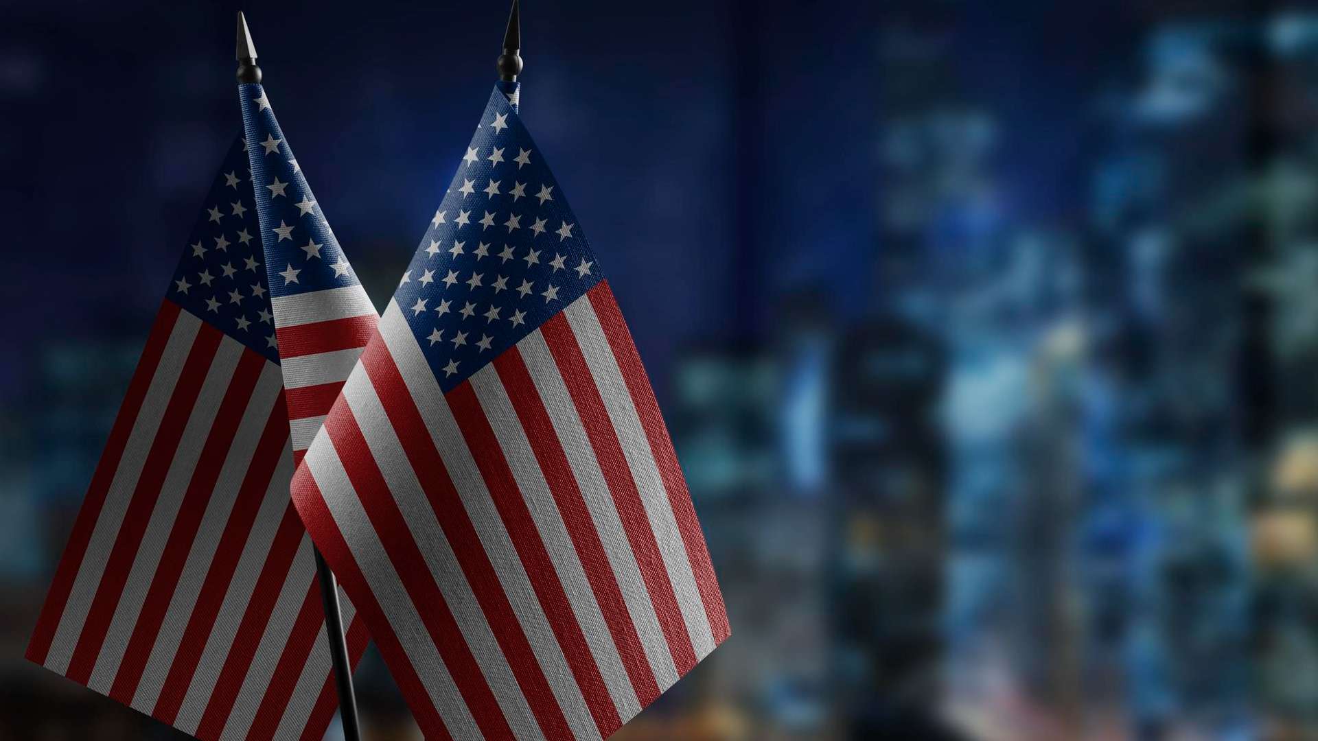 Bandeira dos Estados Unidos em destaque com predios ao fundo