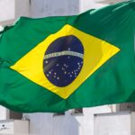 Novos Decretos Chocam: Regras Afiadas Para Empresas Digitais Abalam o Mercado Cripto! 2 Bandeira do Brasil com predio branco com fundo