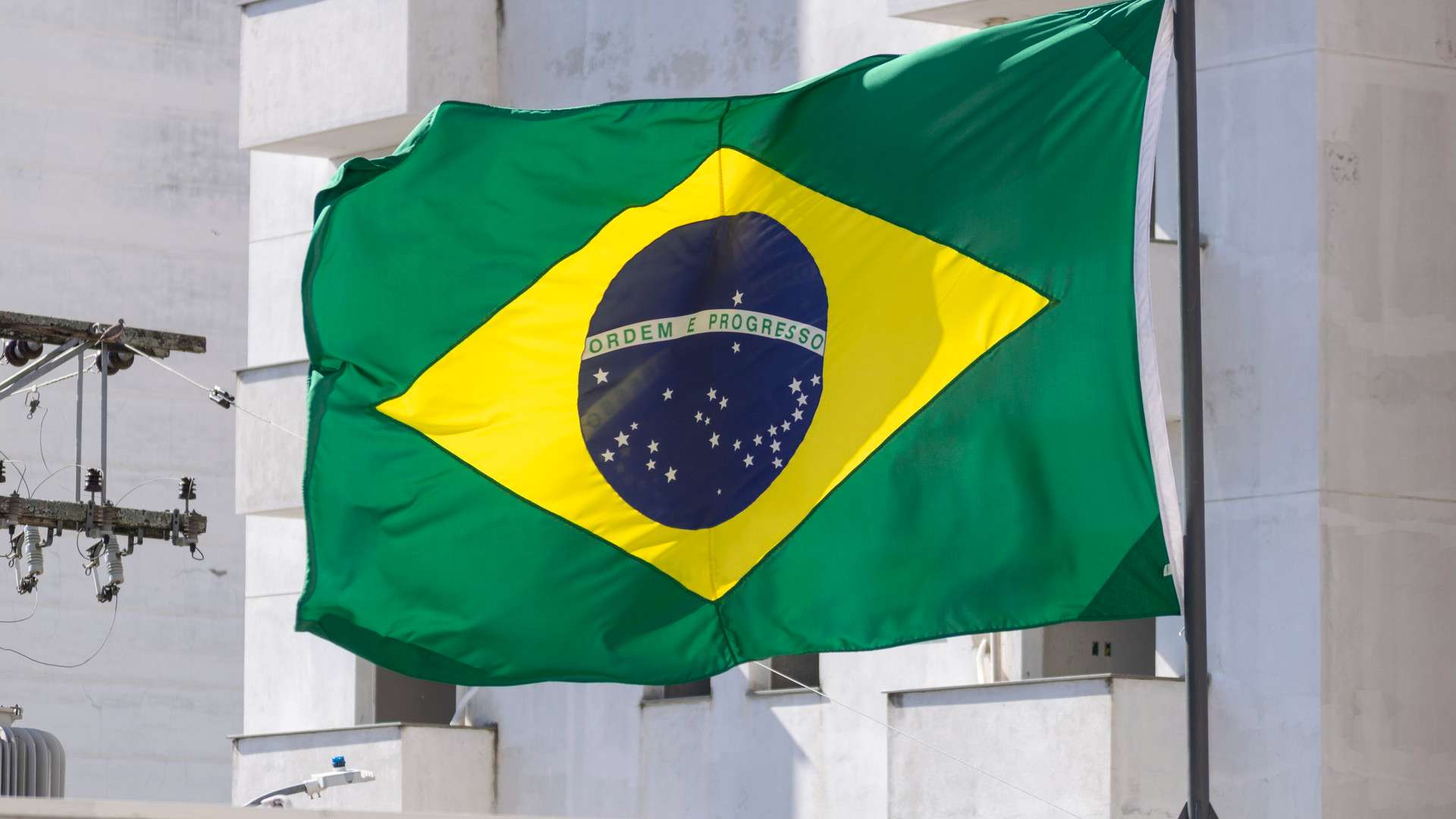 Novos Decretos Chocam: Regras Afiadas Para Empresas Digitais Abalam o Mercado Cripto! 2 Bandeira do Brasil com predio branco com fundo