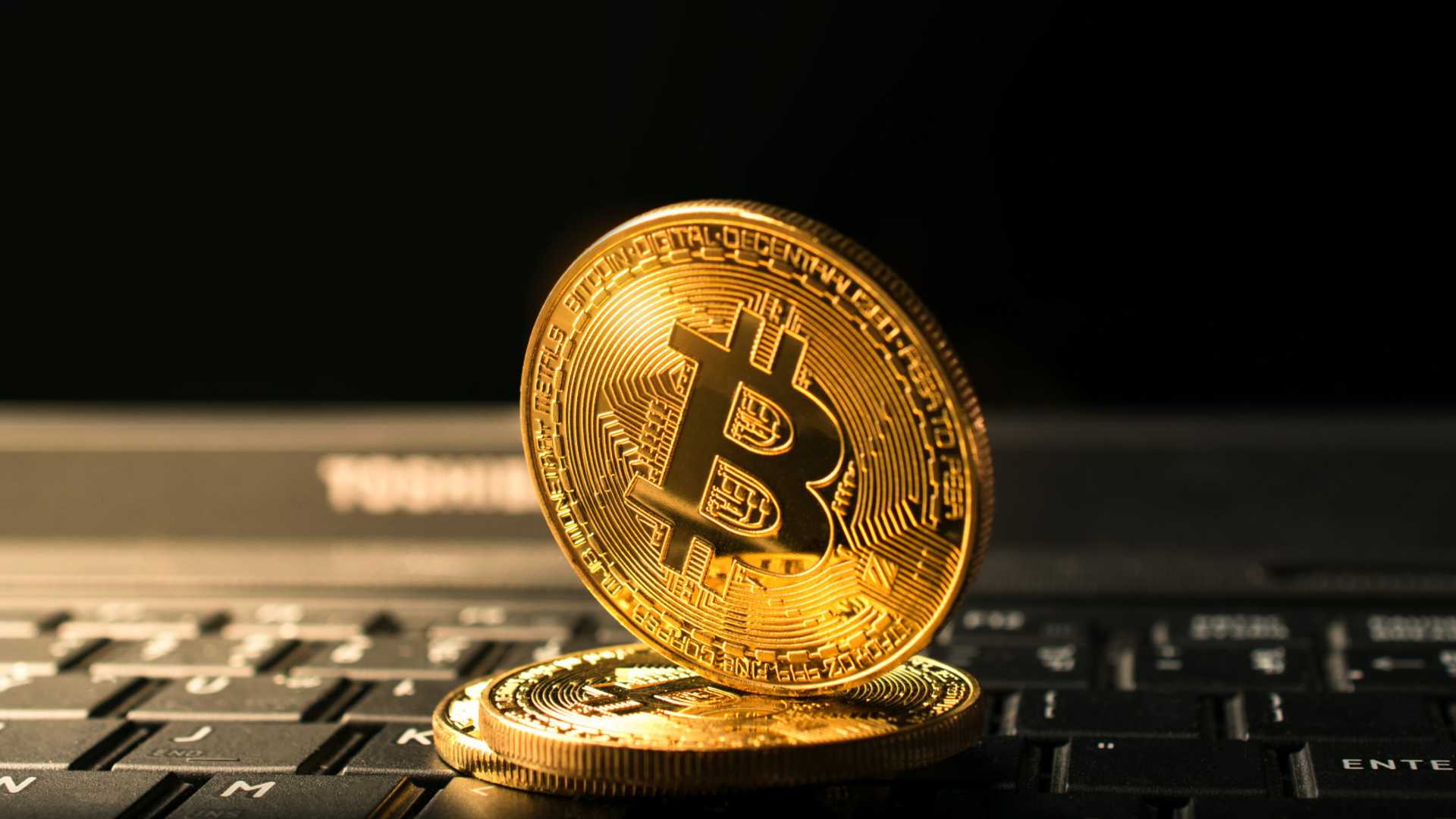 Bitcoin sobre computador apontando para