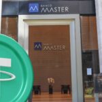 Fachada do Banco Master com logo da Tether
