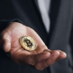 Homem de terno segurando bitcoin em destaque