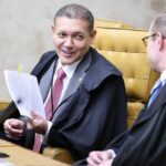 Ministro Nunes Marques segurando papel em sessao do STF