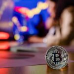 Mulher ao fundo fazendo analise do bitcoin