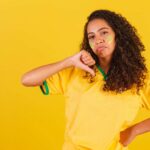 Brasileiros confiam mais em bancos do que em autoridades para combater fraudes digitais! 1 Mulher com camisa do Brasil apontando sinal de negativo