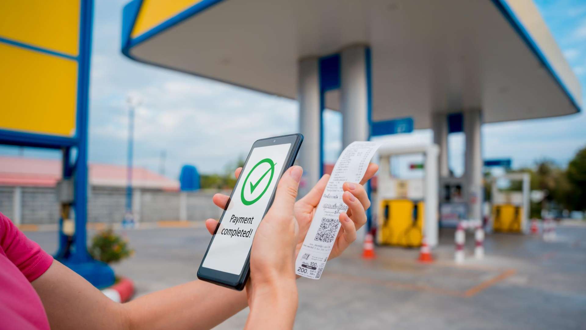 Pessoa pagando em posto de combustivel com aplicativo em celular